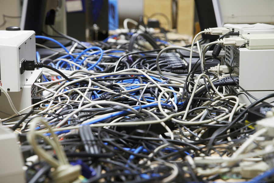 Closeup of messed wires connecting computers and printers in office